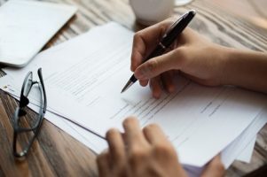 businessman-examining-papers-at-table_1262-3706