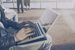 crop-man-using-laptop-at-street_1220-1772