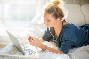 portrait-of-an-attractive-woman-lying-on-bed-with-laptop_1163-1900