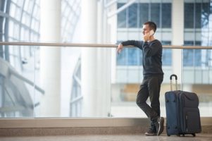 young-traveler-talking-on-smartphone-in-airport_1163-3263